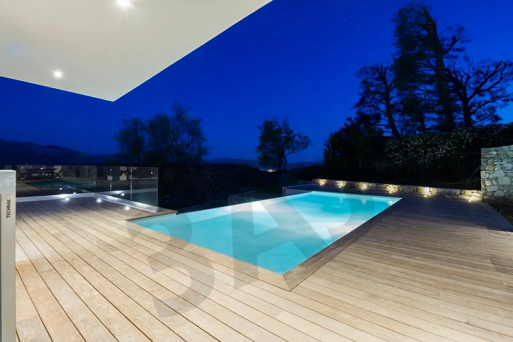 Terrasse et piscine éclairées à la tombée de la nuit