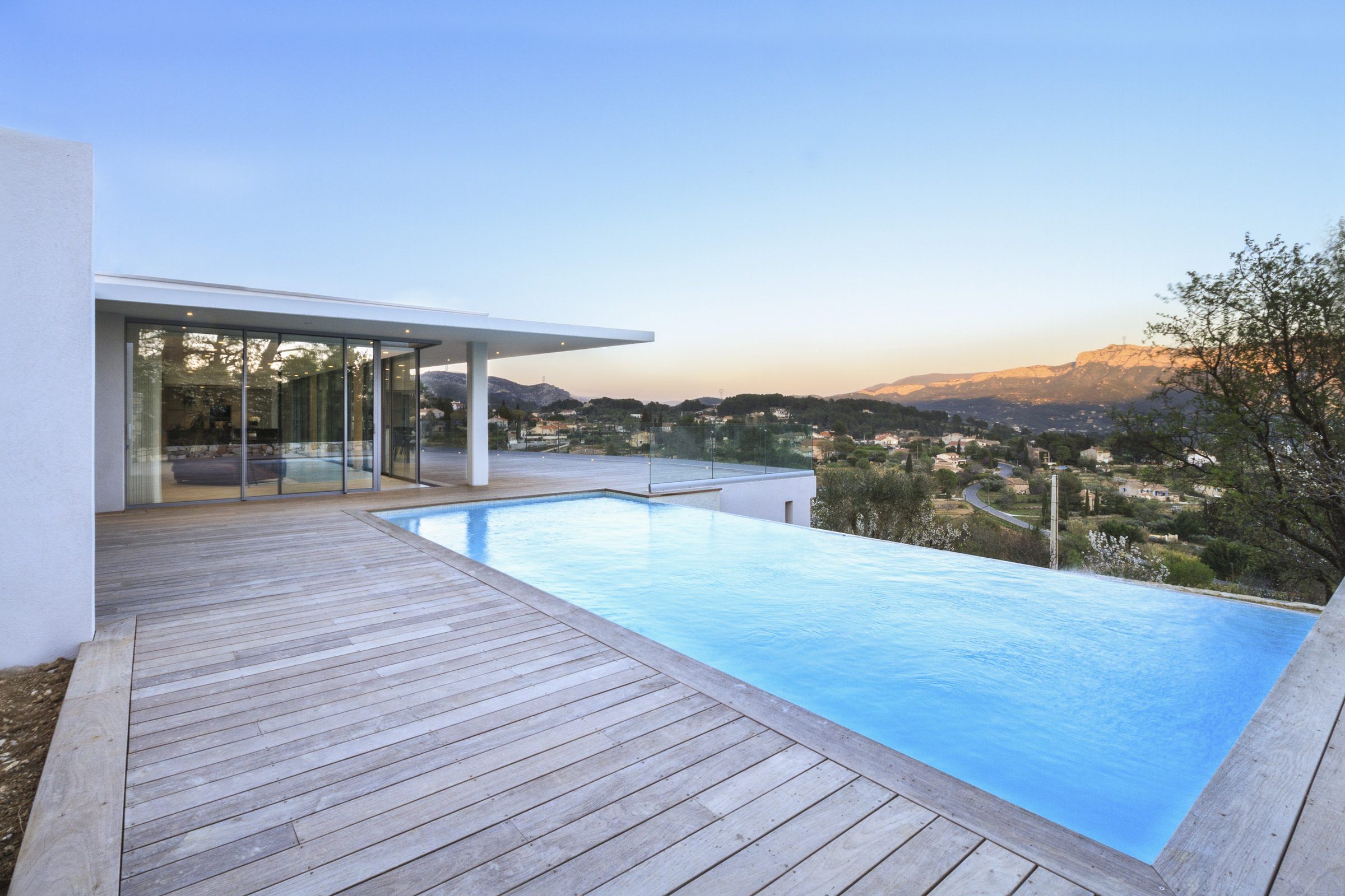 Villa QO01 à l'heure bleue, terrasse en bois et piscine à débordement face aux reliefs